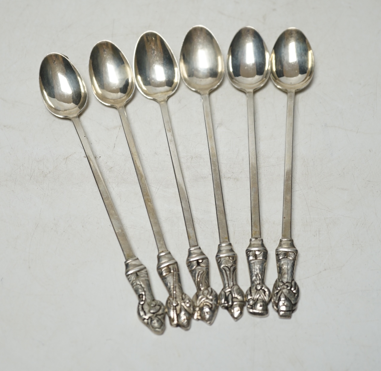 A set of six South American? white metal sundae spoons , each with figural finials, stamped 'Argent', 17.3cm, 121 grams. Condition - fair